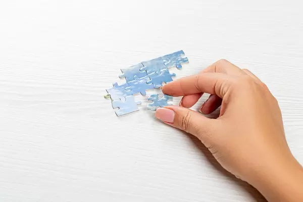 Close up of hand placing piece in puzzle