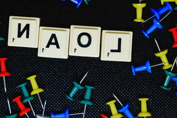 Close up of Loan text on black background with pins (Flip 2019)