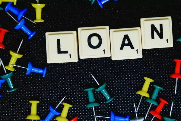 Close up of Loan text on black background with pins