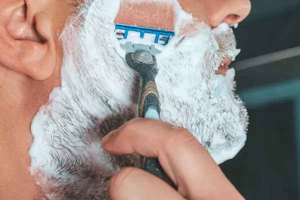 Close up of male face in shaving foam and razor (Flip 2019)