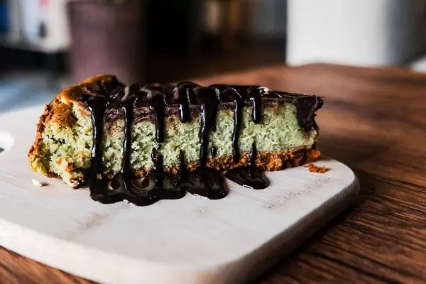 Close up of matcha cheesecake with chocolate fudge