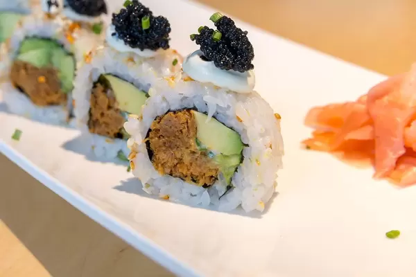 Close-up of measles food and sushi for vegans, with vegetable foods like avocado, spring onions, vegan tonno, vegan caviar and spicy sauce