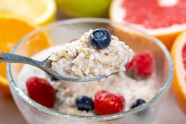 Close-up of oatmeal with berries and milk in a spoon
