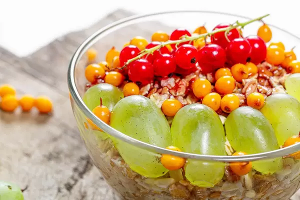 Close up of oatmeal with fresh berries in a glass bowl