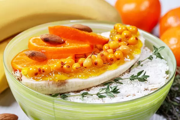 Close-up of oatmeal with fruit, nuts and branches of fresh thyme (Flip 2019)