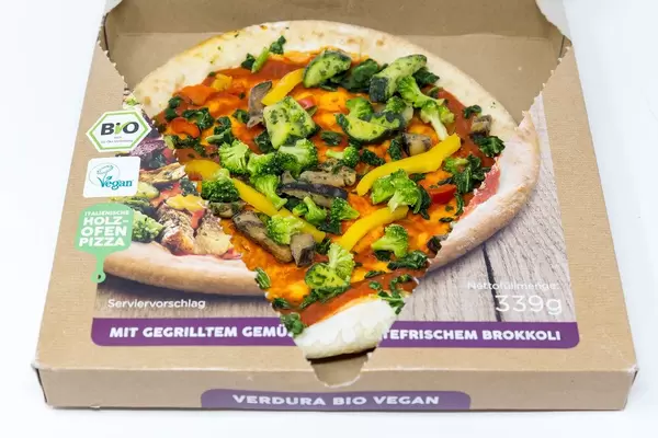 Close-up of open package of followfood vegan pizza with grilled veggies, fresh broccoli and spelt dough