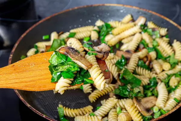 Close-up of pasta, mushrooms, herbs and spices on a wooden kitchen spatula (Flip 2019)