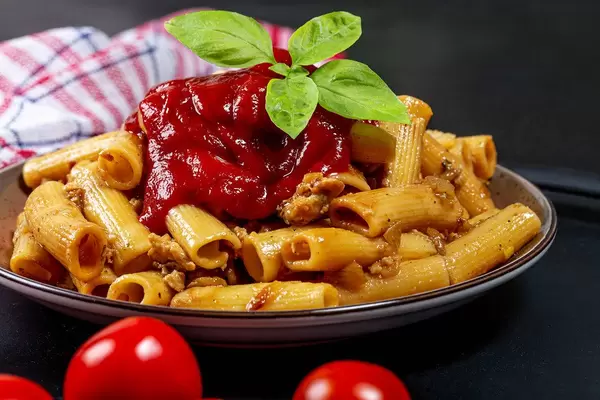 Close-up of pasta with chicken, tomato sauce and basil leaves (Flip 2019)