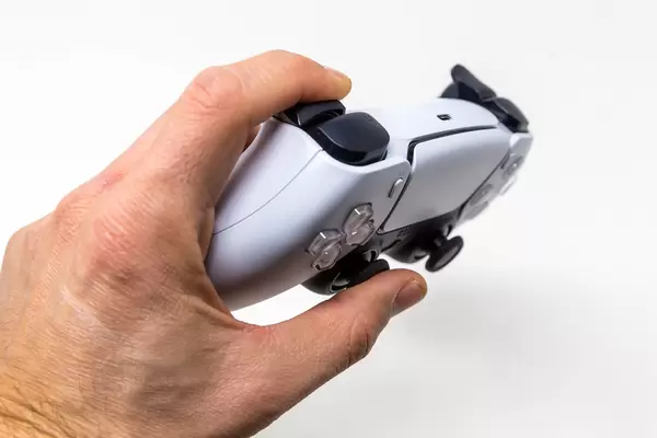 Close-Up of Person holding a Sony PlayStation DualSense Wireless Controller on White Background