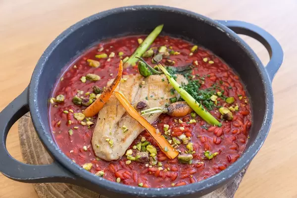 Close-up of pot with rice in beetroot sauce, grilled veggies, chicken breast at Abbaco, Port de Pollença