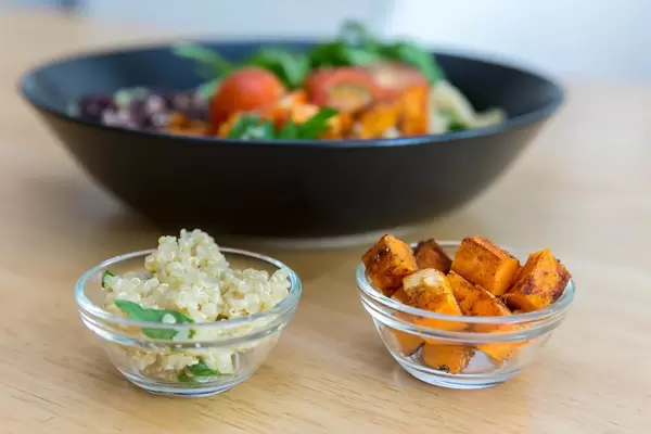 Close-up of quinoa and roasted sweet potatoes in tiny glass bowls
