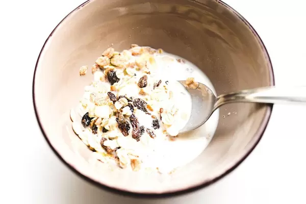 Close up of raisin oat muesli and milk in a bowl