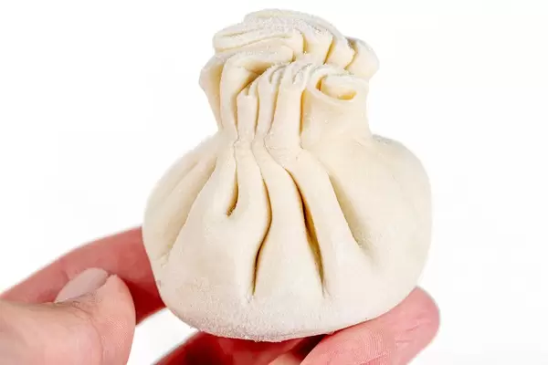Close-up of raw khinkali in a woman's hand