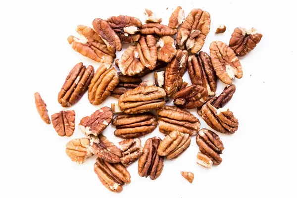 Close up of raw pecan nuts on white background