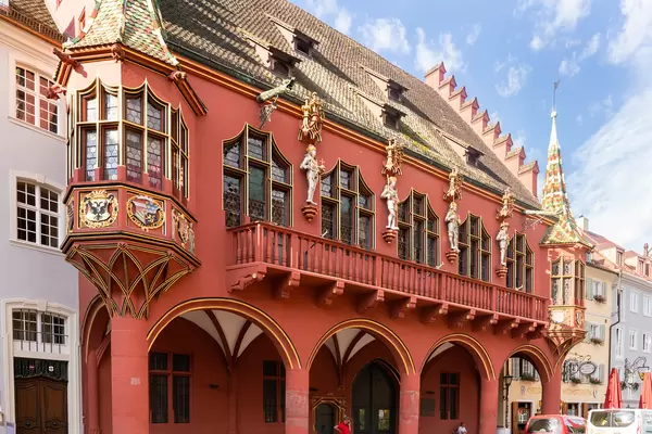 Close up of red luxurious Merchants' Hall building with figurines and coat of arms ornaments