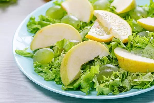 Close-up of salad with apples, grapes and lettuce in a blue plate (Flip 2019)