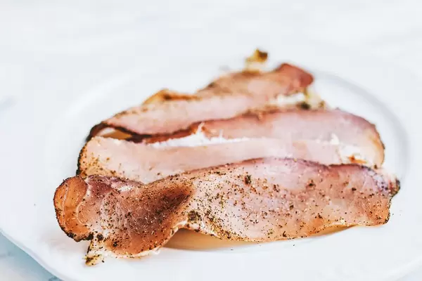 Close up of sliced roasted meat on white background