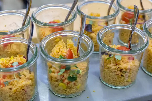 Close-up of small jars filled with vegan couscous salad made with tomato, red onion and corn at the BarCamp in Bonn