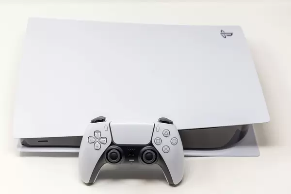 Close-Up of Sony DualSense Wireless Controller in front of a laying Sony PlayStation 5 Digital Edition on White Background