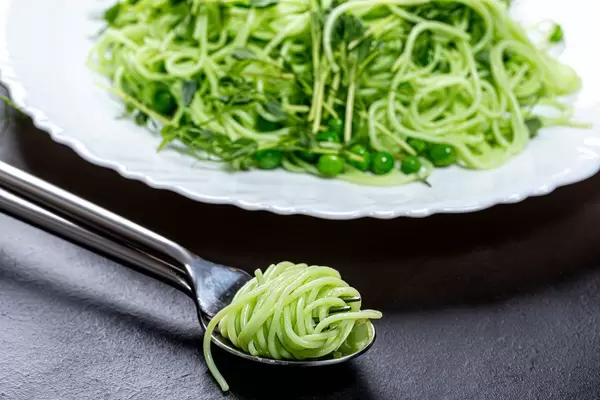 Close up of spinach spaghetti wound on a fork