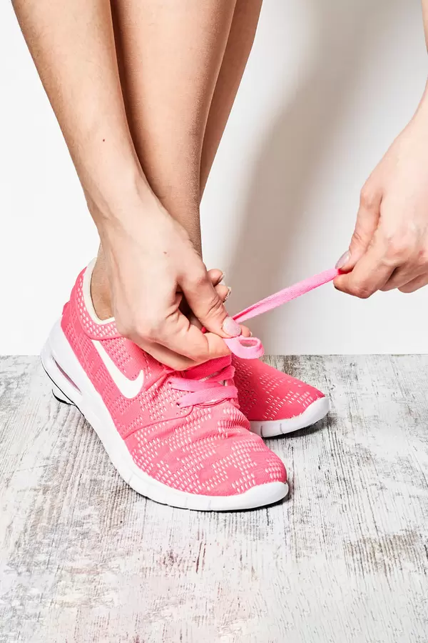 Close-up of sportswoman putting on sneakers.