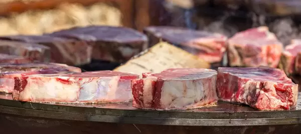 Close-up of still raw, juicy chops on OFŸR grill plate at Tomorrowland Festival 2019