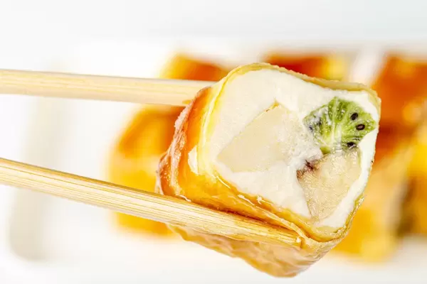Close-up of sweet rolls with fruit and chopsticks (Flip 2020)