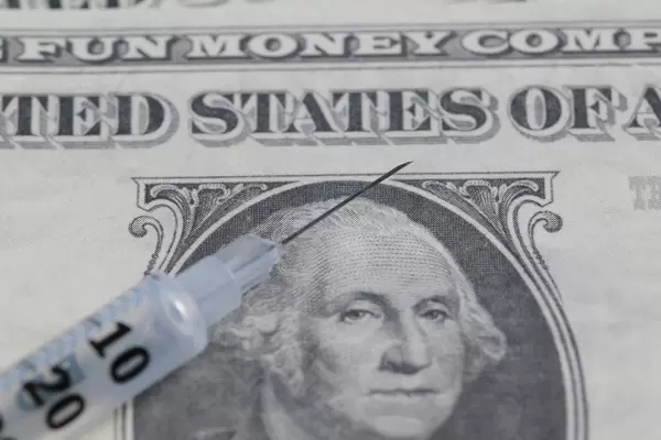 Close up of syringe with money