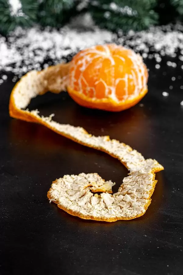 Close up of tangerine with peeled peel on dark background