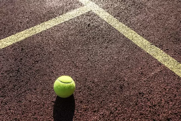 Close Up of Tennis Ball on Tennis Hard Court at Sunny Weather