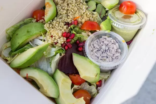 Close-up of the mixed Insalata QUINOA AVOCADO from L'Osteria, with pomegranate, sunflower seeds, chia and ruccola dressing