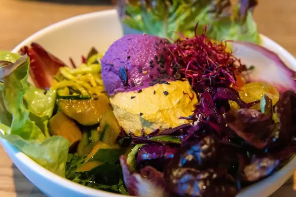 Close-up of the Raw Superbowl at Flax&Kale in Barcelona, with ball of red cabbage, cucumber asazuke and cherry tomatoes with salad