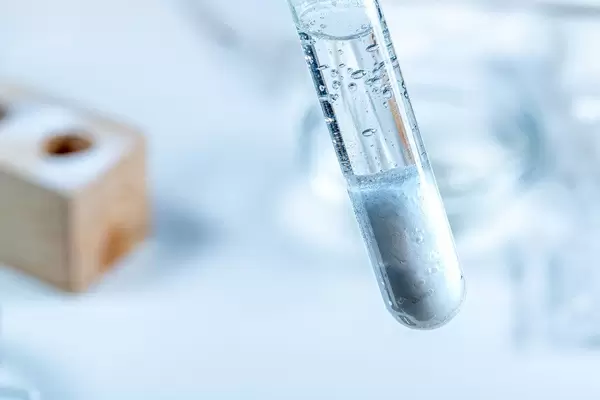 Close-up of the reaction between alkaline and acidic reagents in a test tube