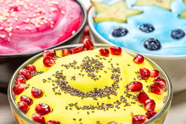 Close up of three versions of oatmeal with fruit and seeds