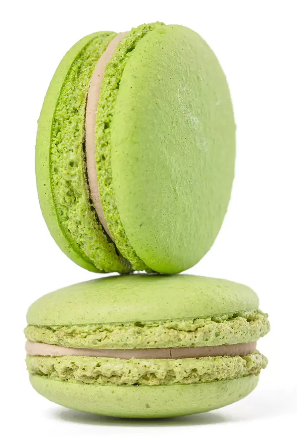 Close-up of two green macaroons on white
