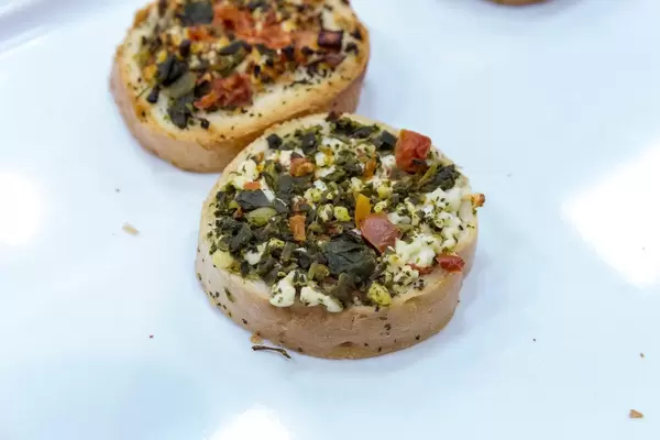 Close-up of vegetarian bruschettes with feta cheese-spinach-dried tomato topping at the BarCap in Bonn