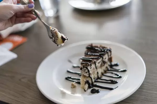Close Up on the Hand Holding a Piece of Cake on a Fork