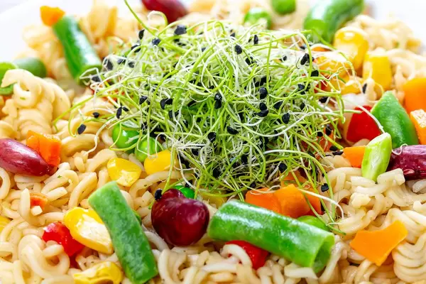 Close - up pasta with vegetables and micro onion greens (Flip 2019)