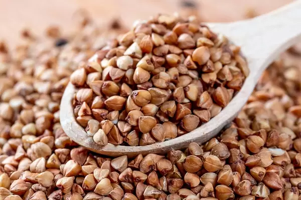 Close Up Photo of Buckwheat in a Wooden Spoon