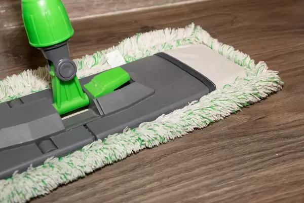 Close Up Photo of Cleaning Mop on a Brown Wooden Floor