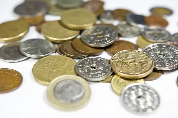 Close Up Photo of Coin Collection consisting many different Coins on White Background
