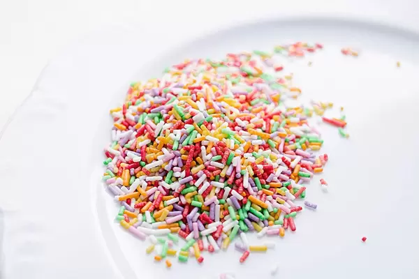 Close Up Photo of Colorful Sprinkles on a White Plate