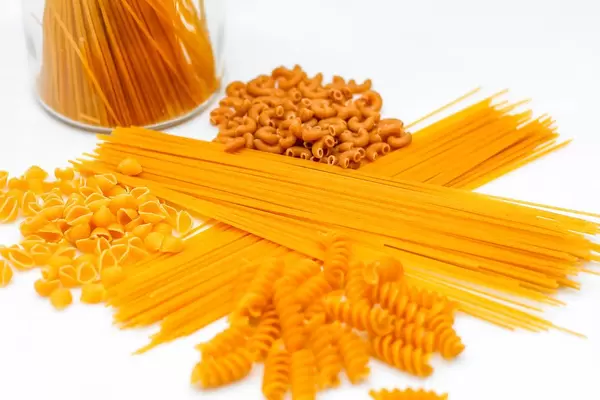 Close Up Photo of different kinds of Pasta like Spaghetti, Fusilli and Macaroni on white Background