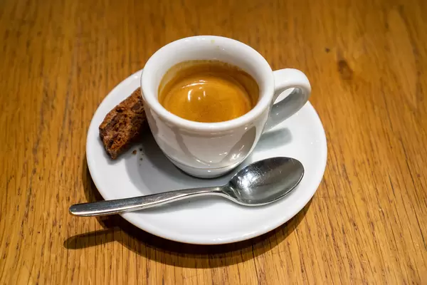 Close Up Photo of Espresso Cup on a Saucer with Spoon and Chocolate Cookie
