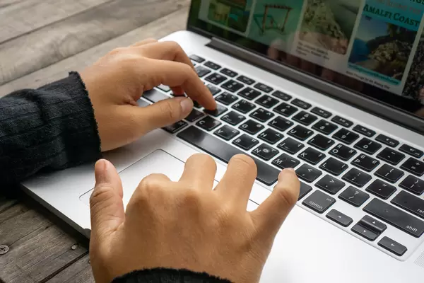Close Up Photo of Female Hands on Laptop Keyboard and Mouse Pad