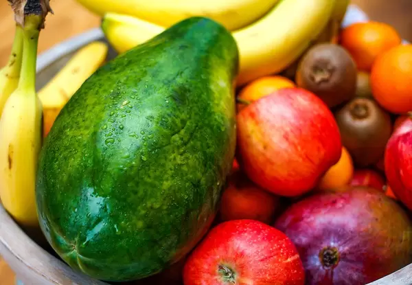 Close Up Photo of Fresh Papaya in a Basket with Apples, Bananas, Kiwis and other Fruits