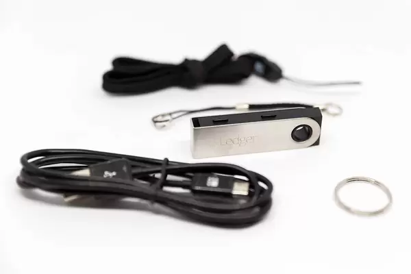 Close Up Photo of Hardware Wallet Ledger Nano S with Black Data Cable and other Accesories on White Background