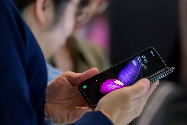 Close Up Photo of Person using the Samsung Galaxy Fold Smartphone with 5G and Foldable Display at a Fair