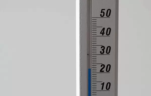 Close Up Photo of Thermometer showing 23 degrees Room Temperature on White Background