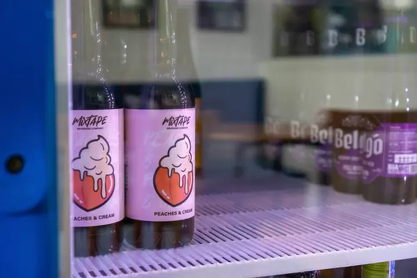 Close Up Photo of Vietnamese Craft Beer with Peaches and Cream Flavor and Belgo Belgian Craft Beer inside a Beverage Fridge